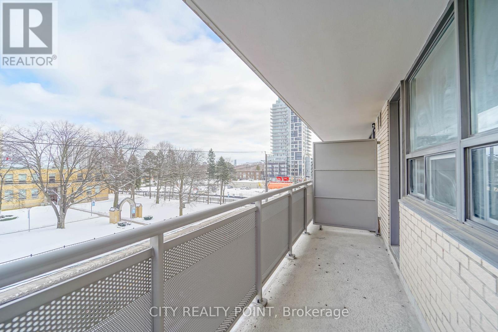 A balcony with a metal railing overlooking a snowy landscape.