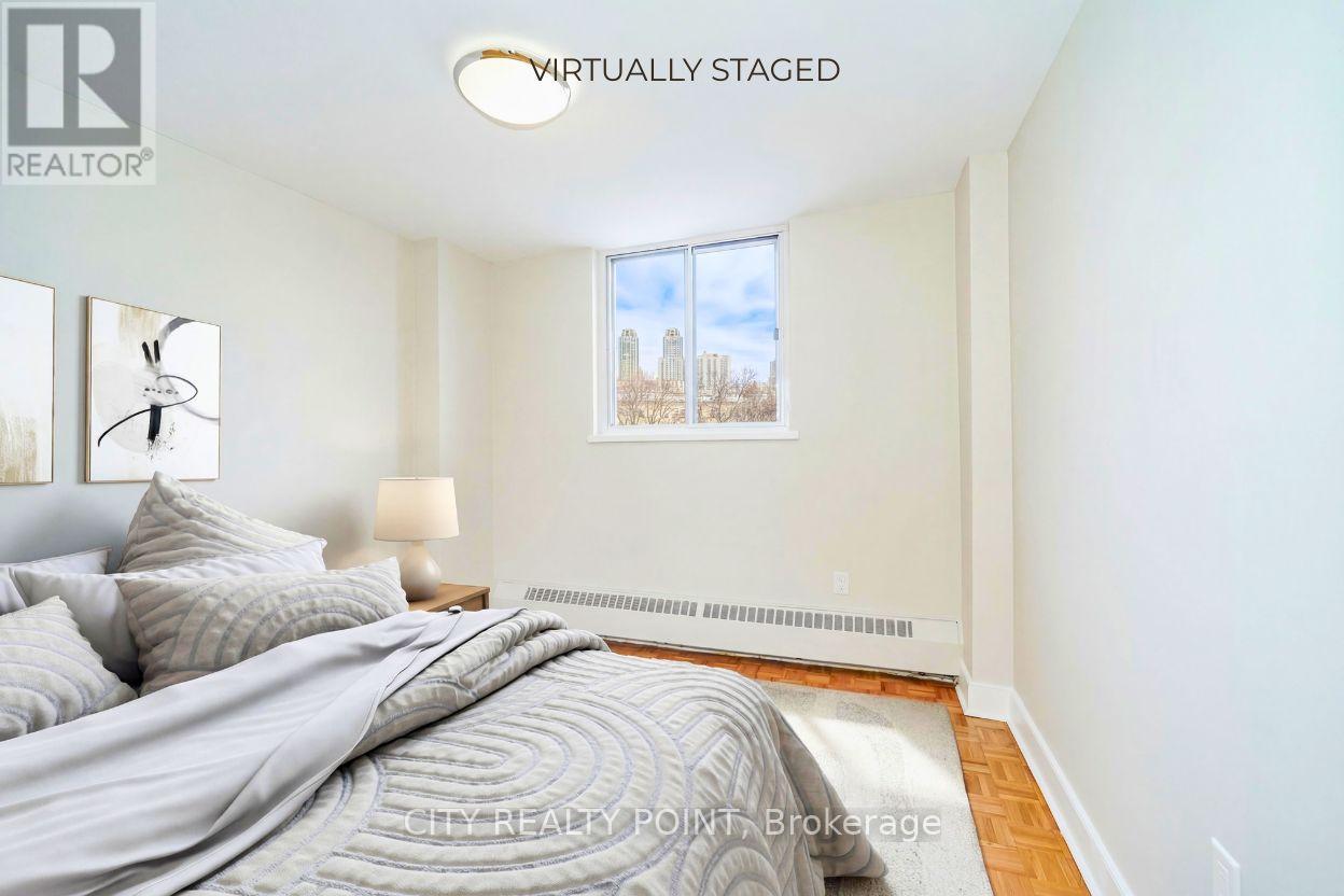 A bedroom with a bed, lamp, and window.