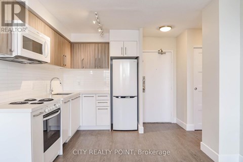 A kitchen with white appliances and wooden cabinets.
