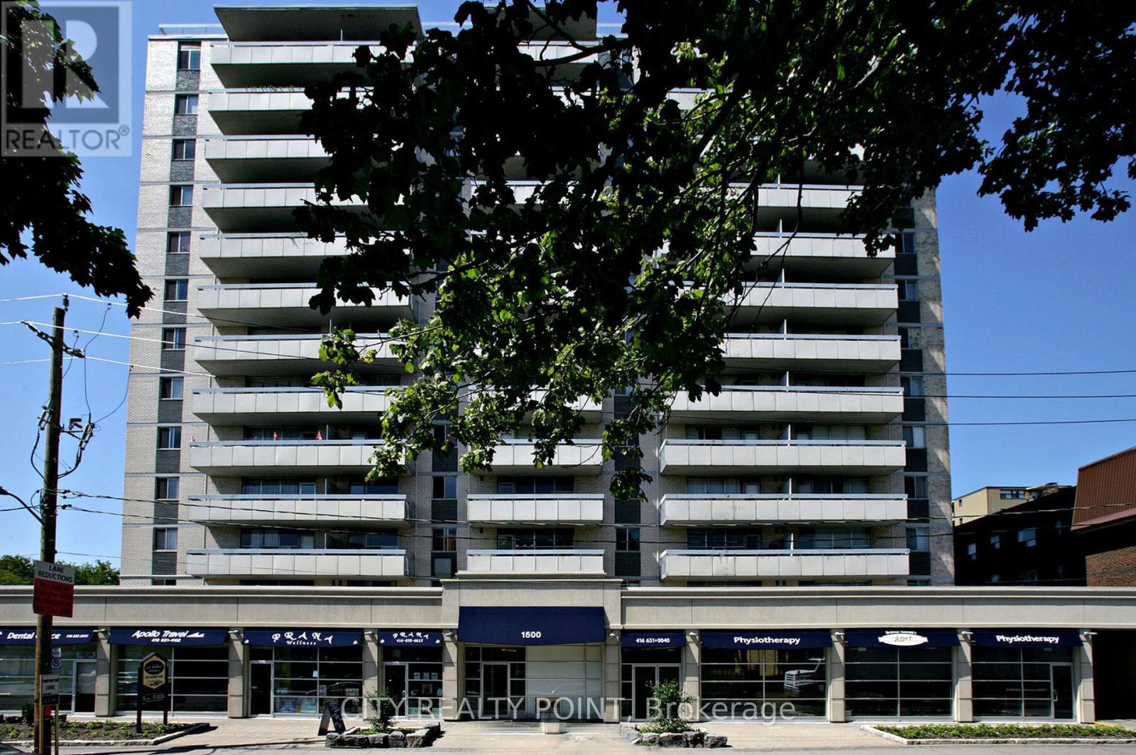 A tall apartment building with a Realty sign in front.
