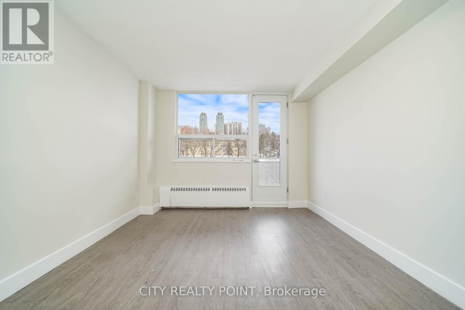 A room with a view of a city skyline through a window.