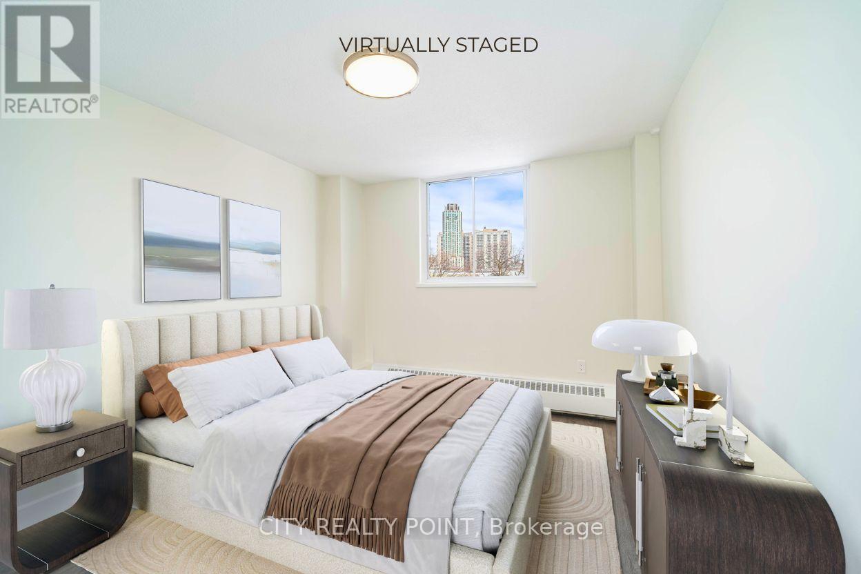 A bedroom with a bed, nightstand, and lamp.