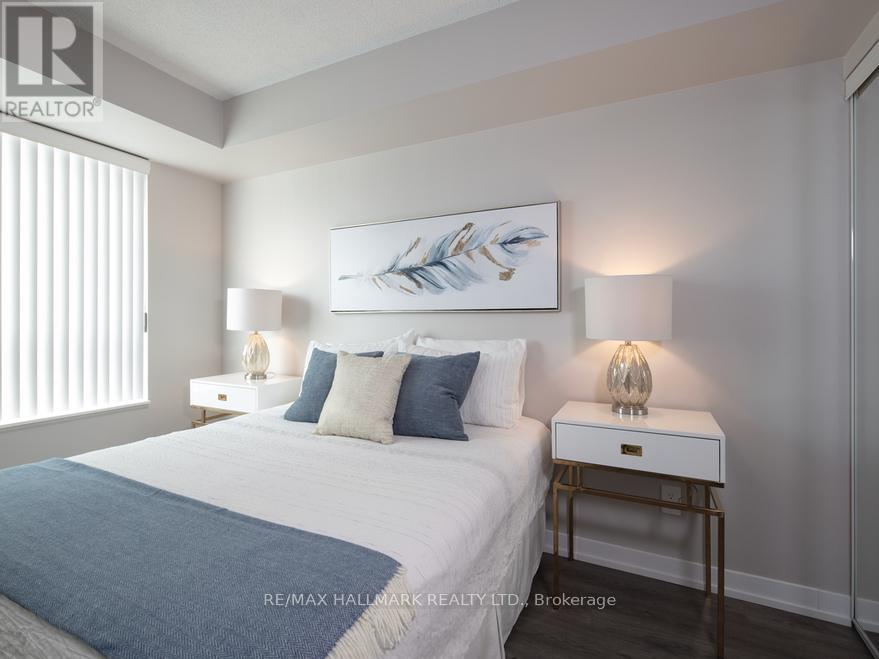 A bedroom with a bed, nightstands, and a painting on the wall.