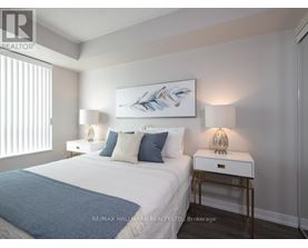A bedroom with a bed, nightstands, and a painting on the wall.