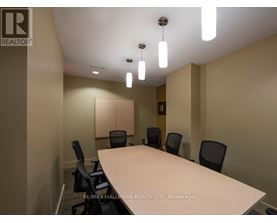 A conference room with a long table and chairs.