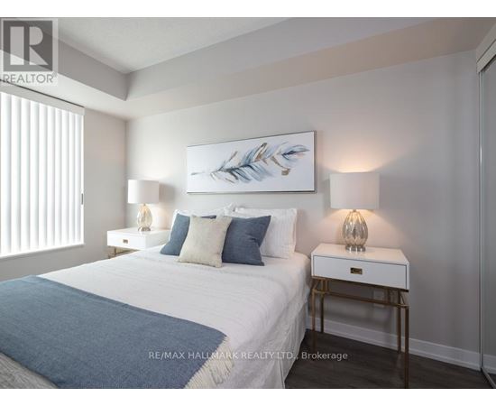 A bedroom with a bed, nightstands, and a painting on the wall.