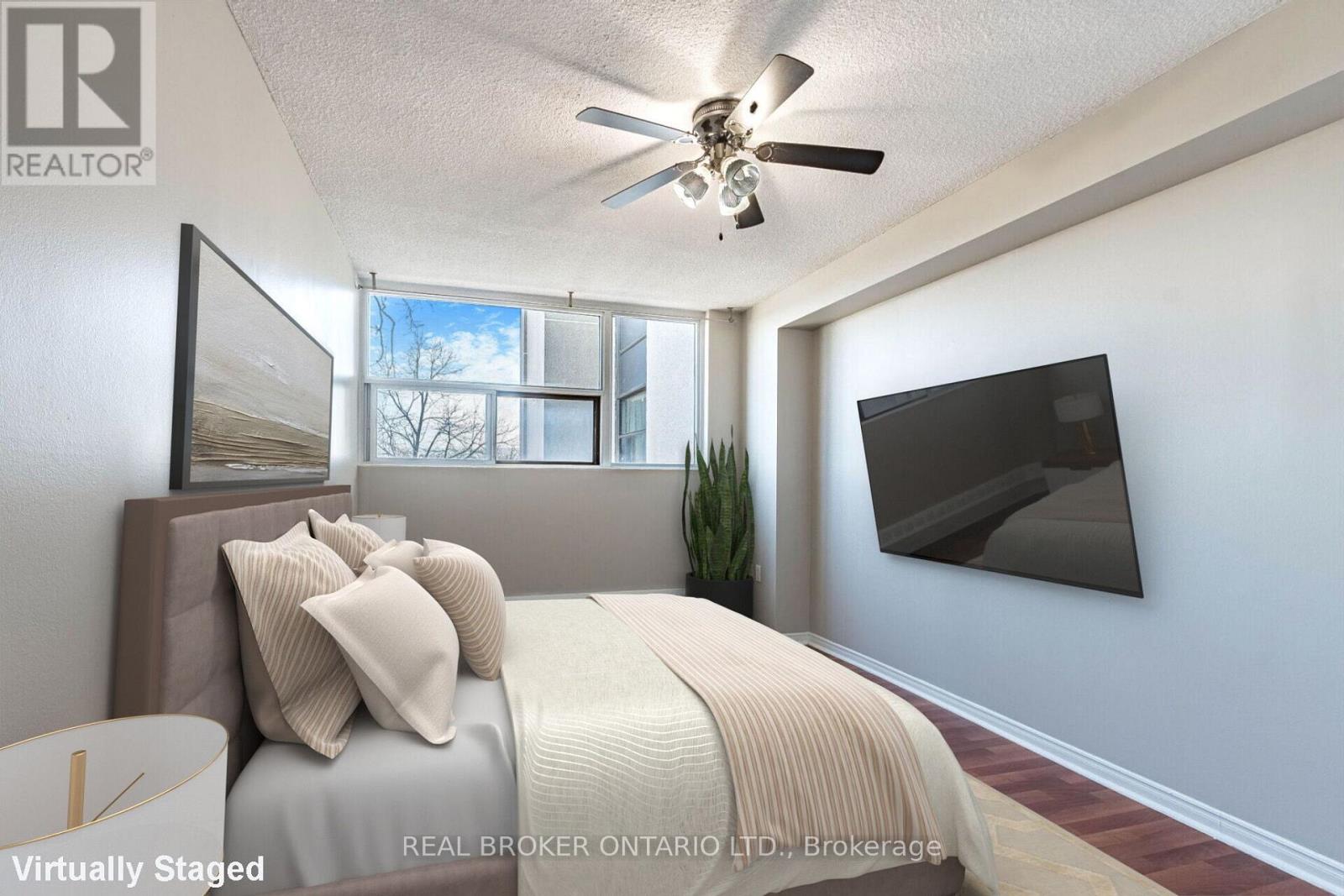 A bedroom with a bed, pillows, a ceiling fan, and a window.