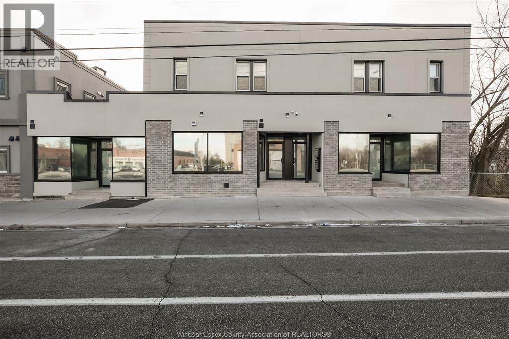 A modern building with a grey facade and a large glass window.