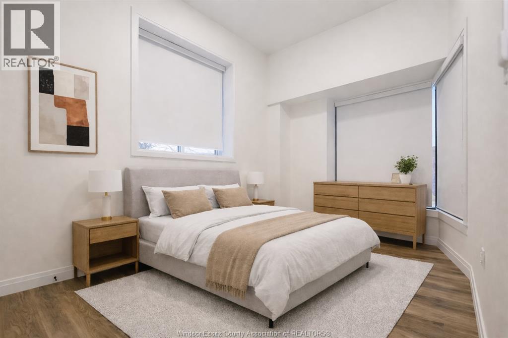 A bedroom with a bed, nightstand, and a painting on the wall.