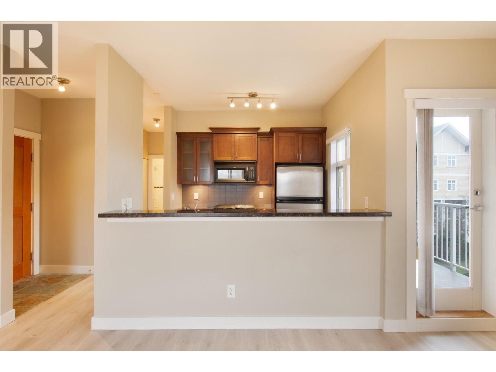 A kitchen with a white countertop and wooden cabinets.
