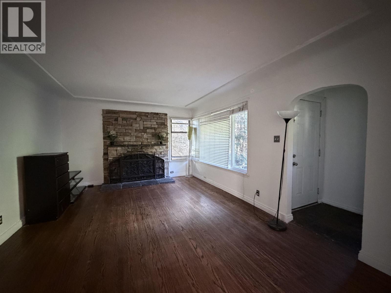 A living room with a fireplace and wood floors.