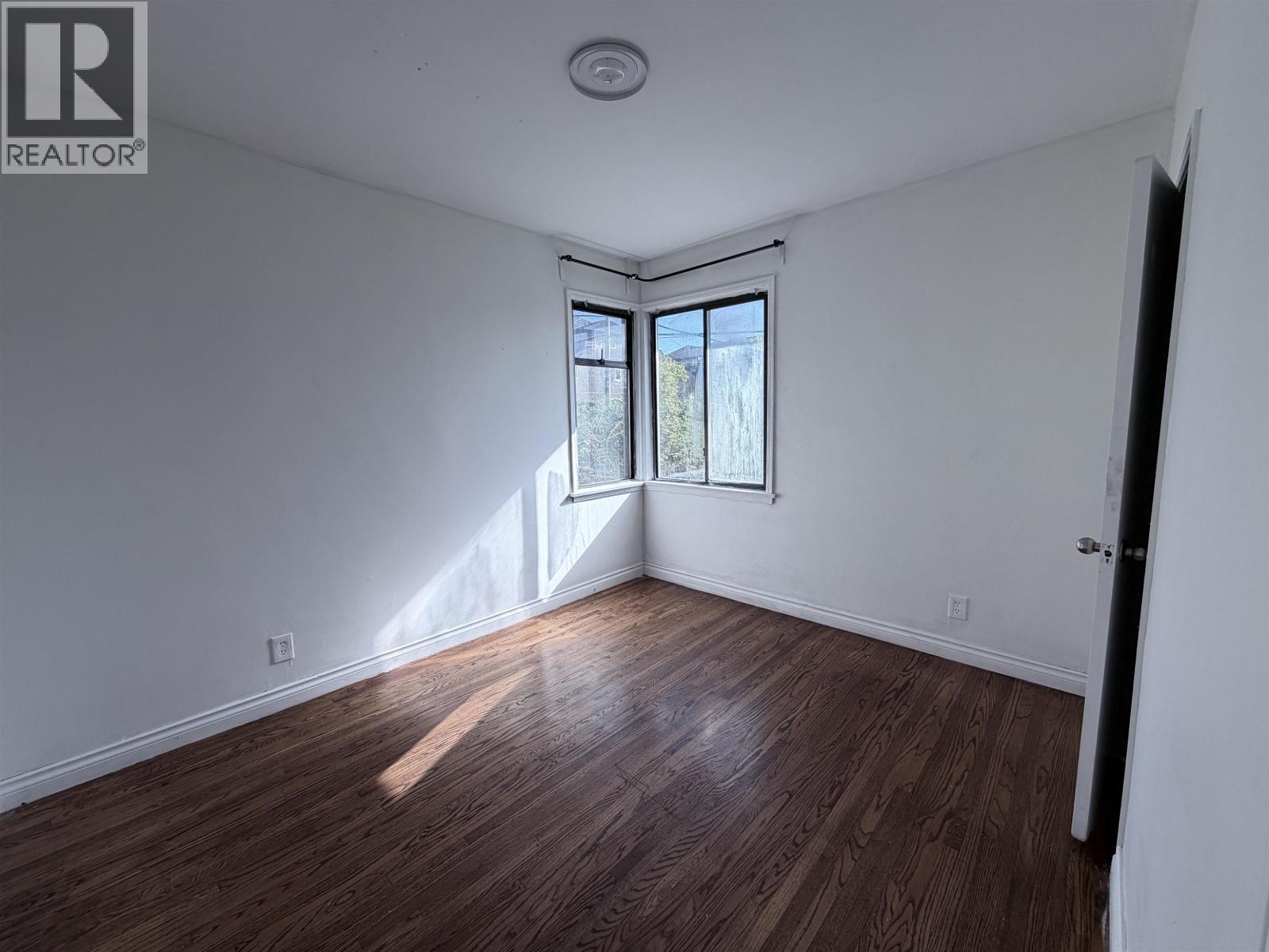 A room with a window and wooden flooring.