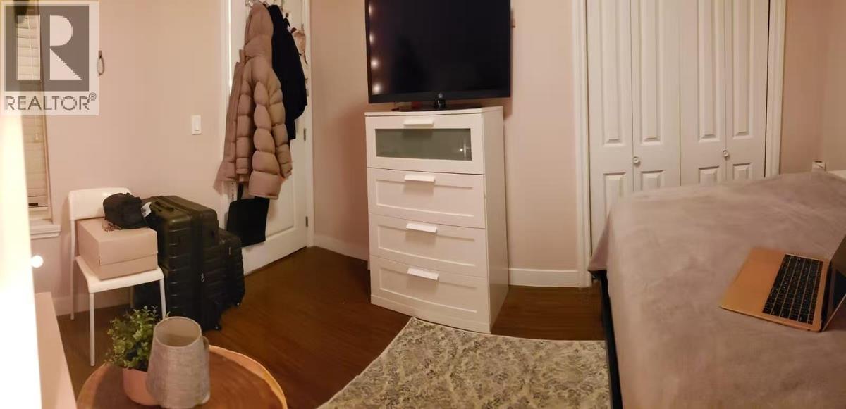 A small room with a bed, a chair, a table, and a TV.