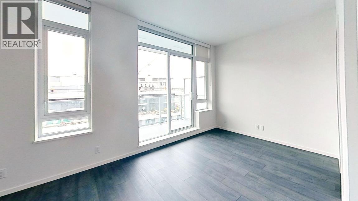 A realtor's office with a large window and a wooden floor.