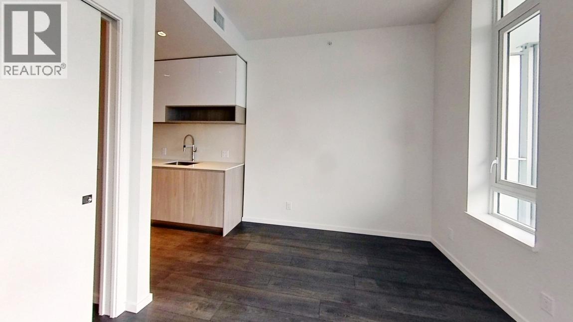 A room with a wooden floor and a window on the right side.