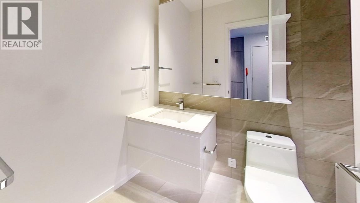 A white bathroom with a sink, toilet and mirror.