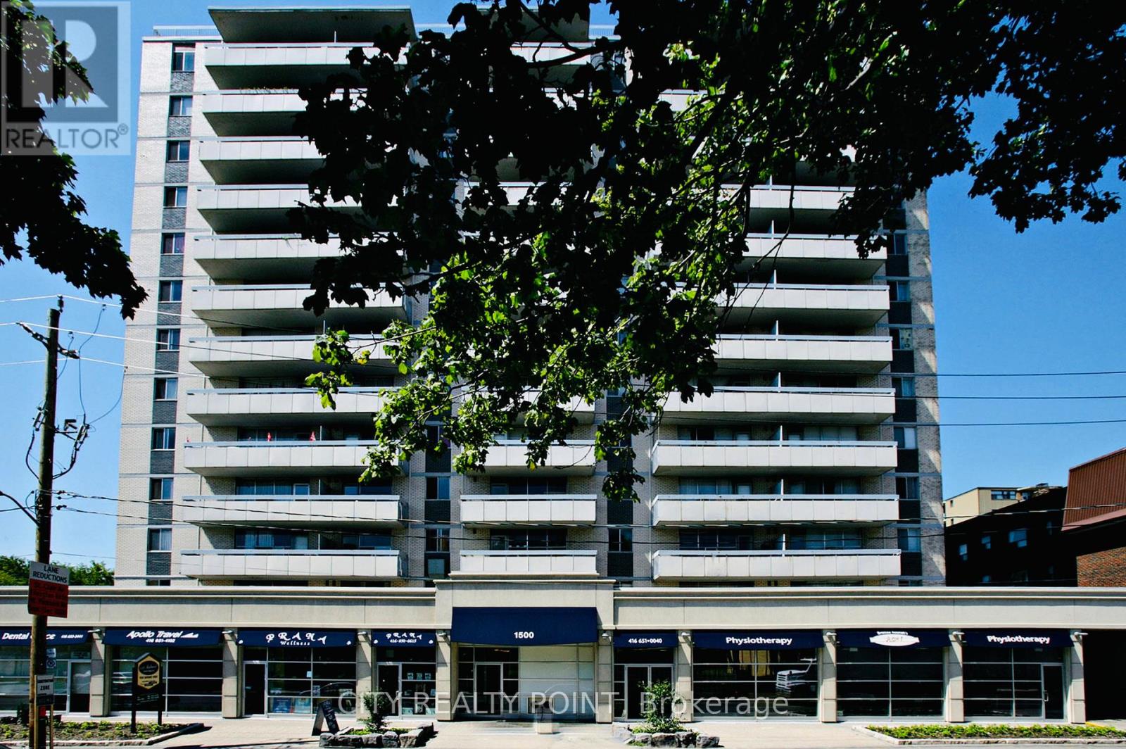A tall apartment building with a REALTOR sign on the front.
