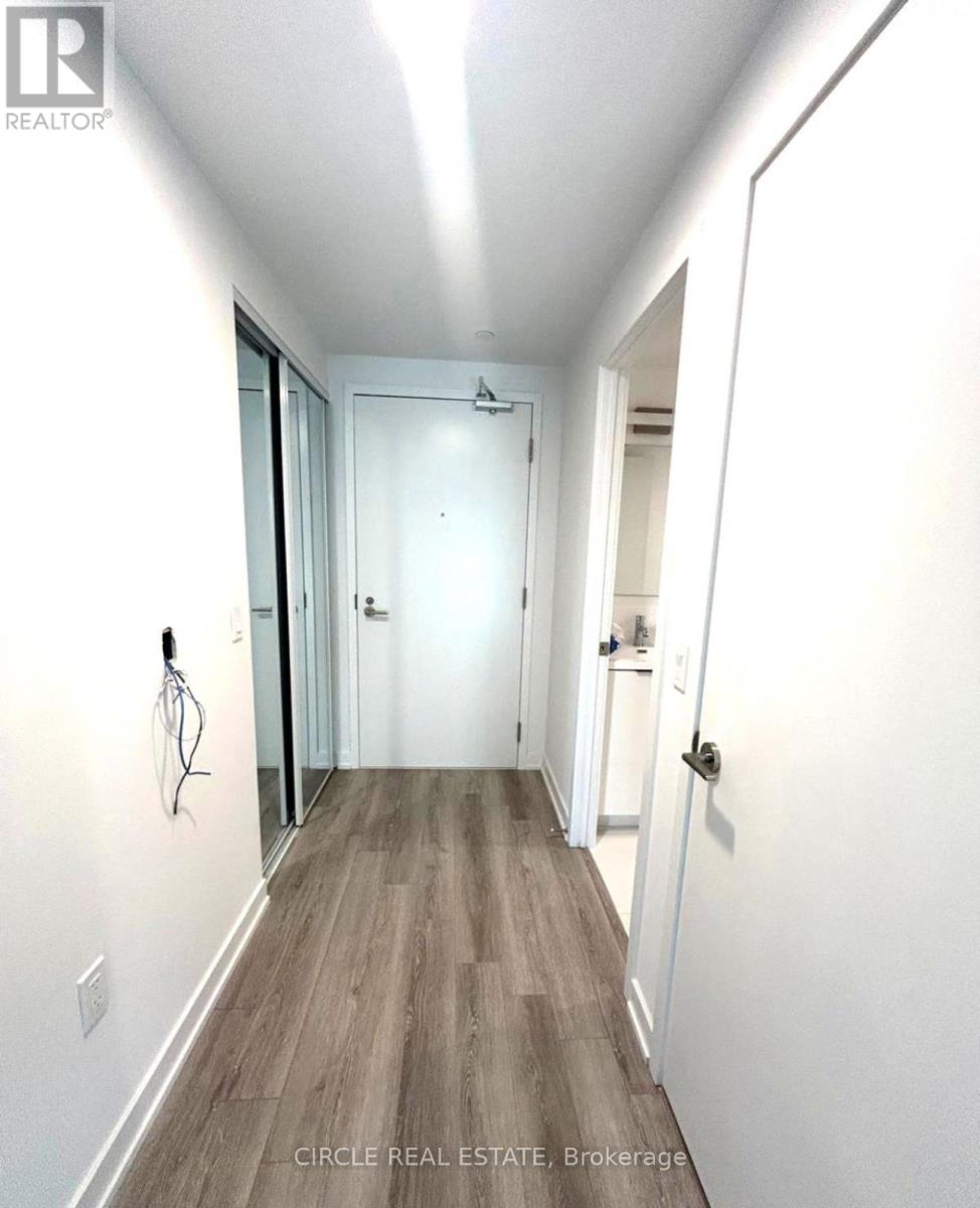 A hallway with wood flooring and white walls.