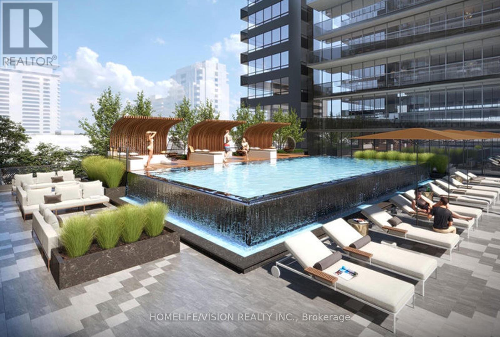 A pool area with lounge chairs and a waterfall.