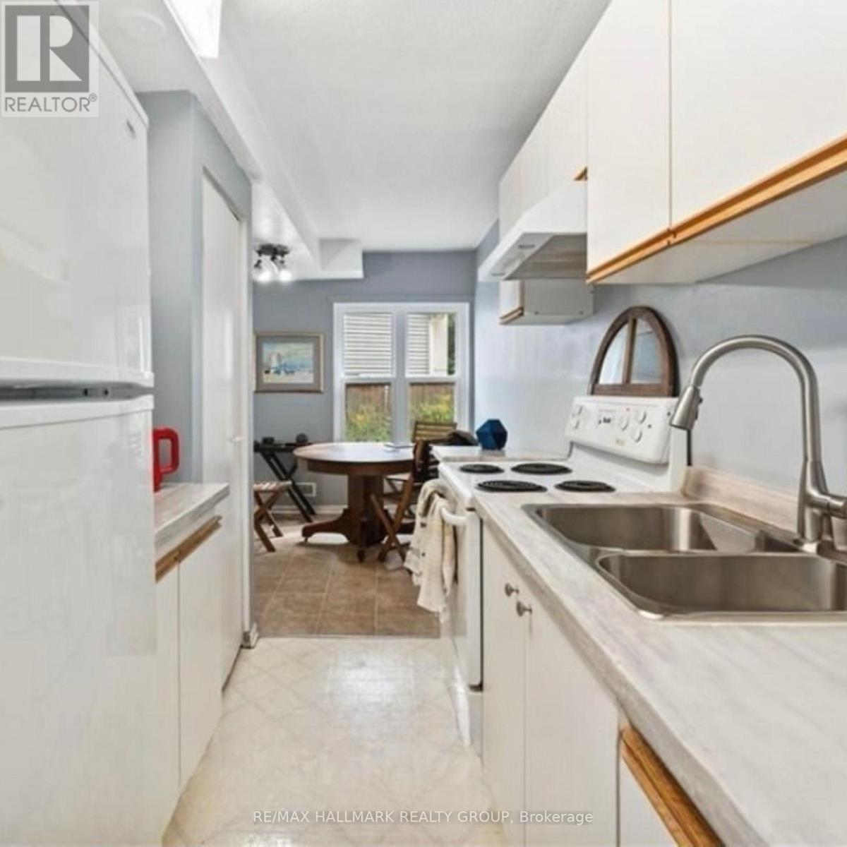 A kitchen with white cabinets and a stainless steel sink.
