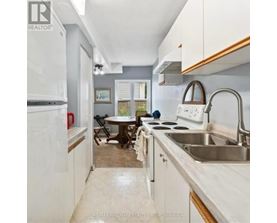 A kitchen with white cabinets and a stainless steel sink.