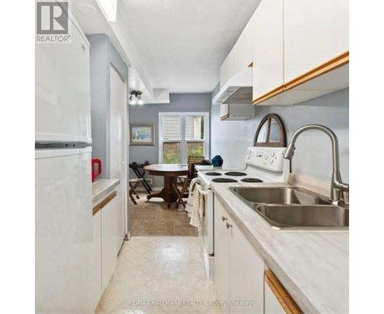 A kitchen with white cabinets and a stainless steel sink.
