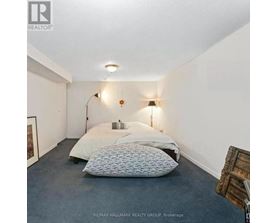 A bedroom with a bed, two pillows, a lamp, and a picture on the wall.
