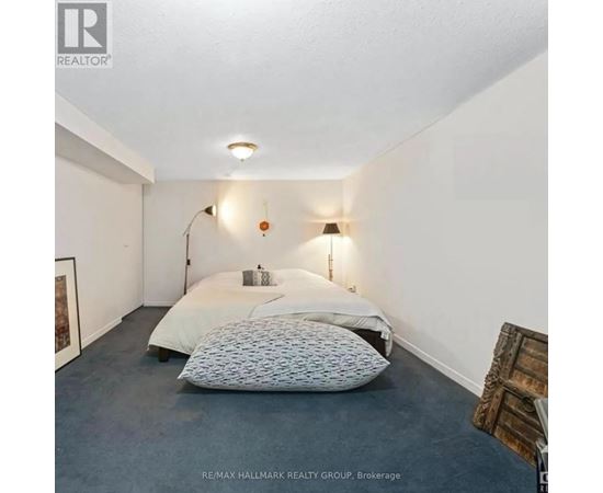 A bedroom with a bed, two pillows, a lamp, and a picture on the wall.
