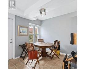 A dining room with a table and chairs.