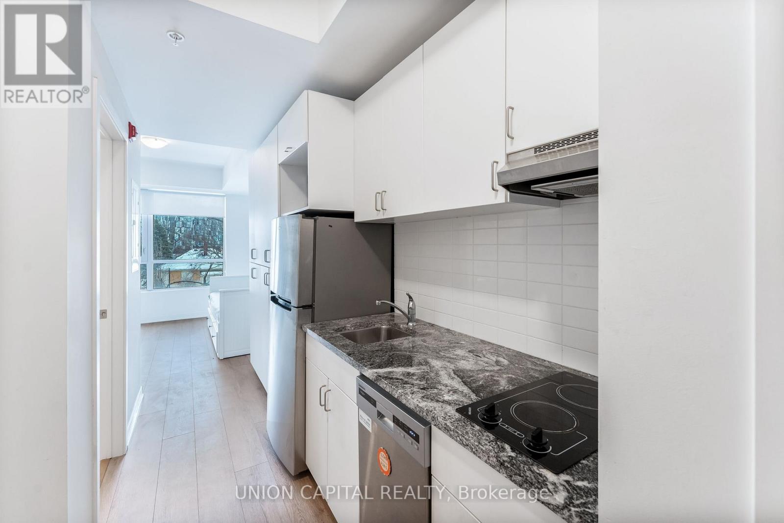 A kitchen with a black stove top oven and white cabinets.