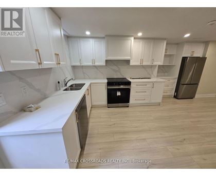A kitchen with white cabinets and a black stove top oven.