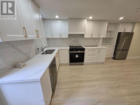 A kitchen with white cabinets and a black stove top oven.