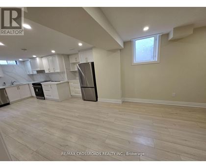 A kitchen with white cabinets and a black refrigerator.