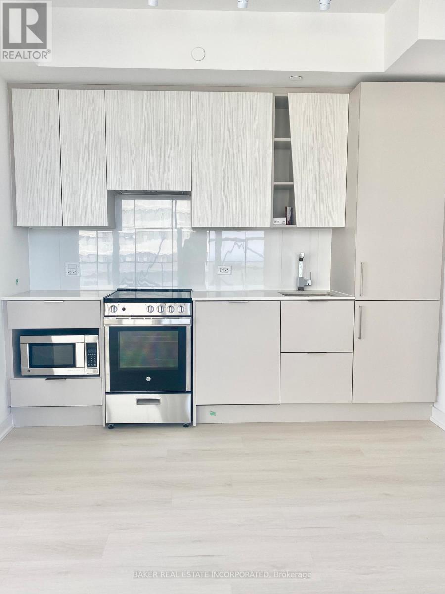 A modern kitchen with white cabinets and stainless steel appliances.