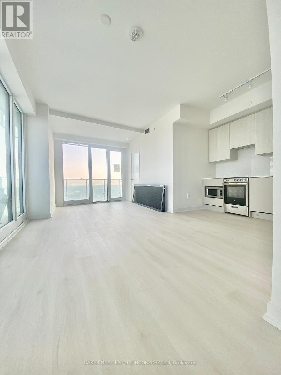 A spacious, empty room with a view of the ocean through large windows.