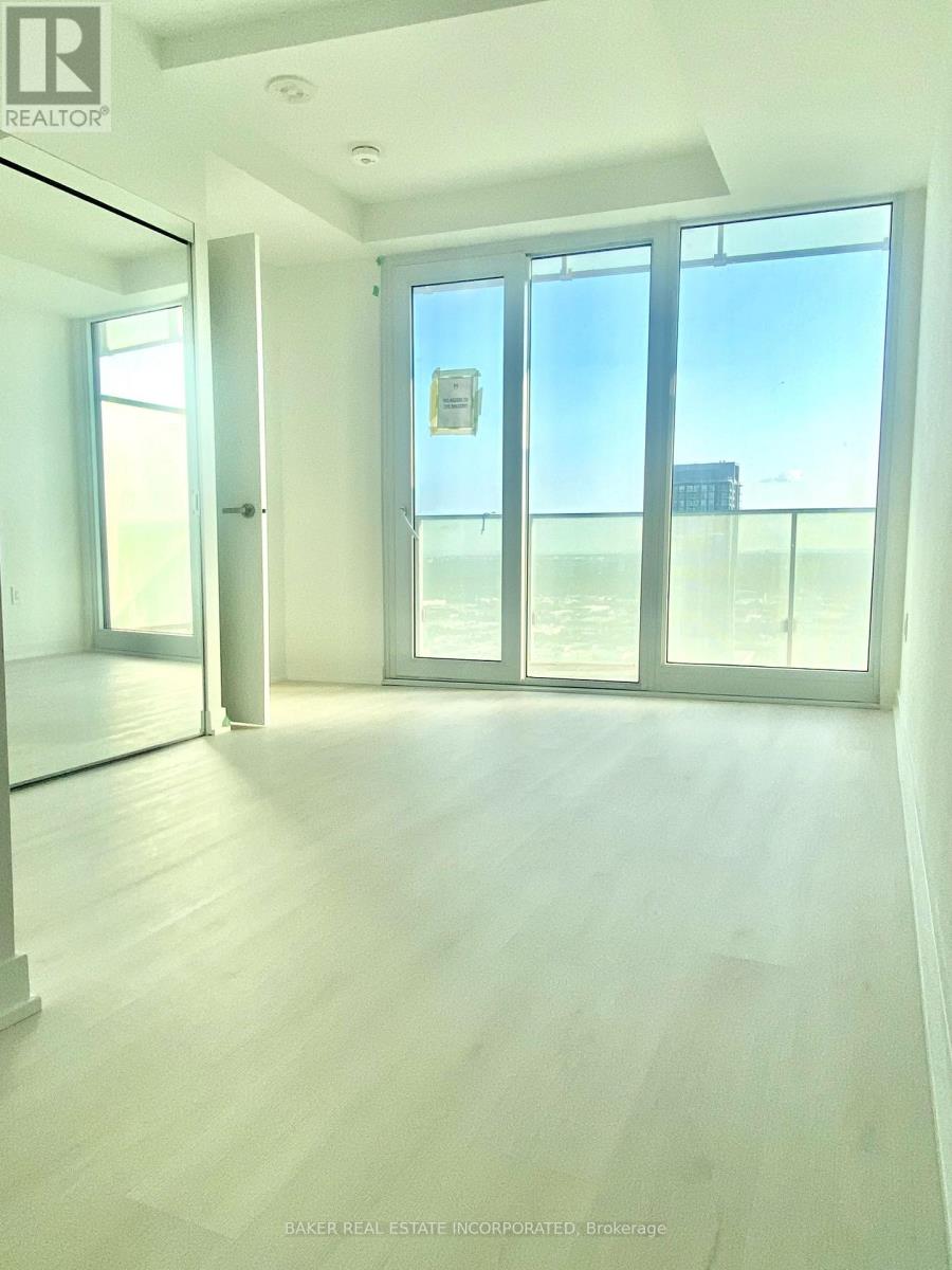 A room with a view of the beach through the windows.