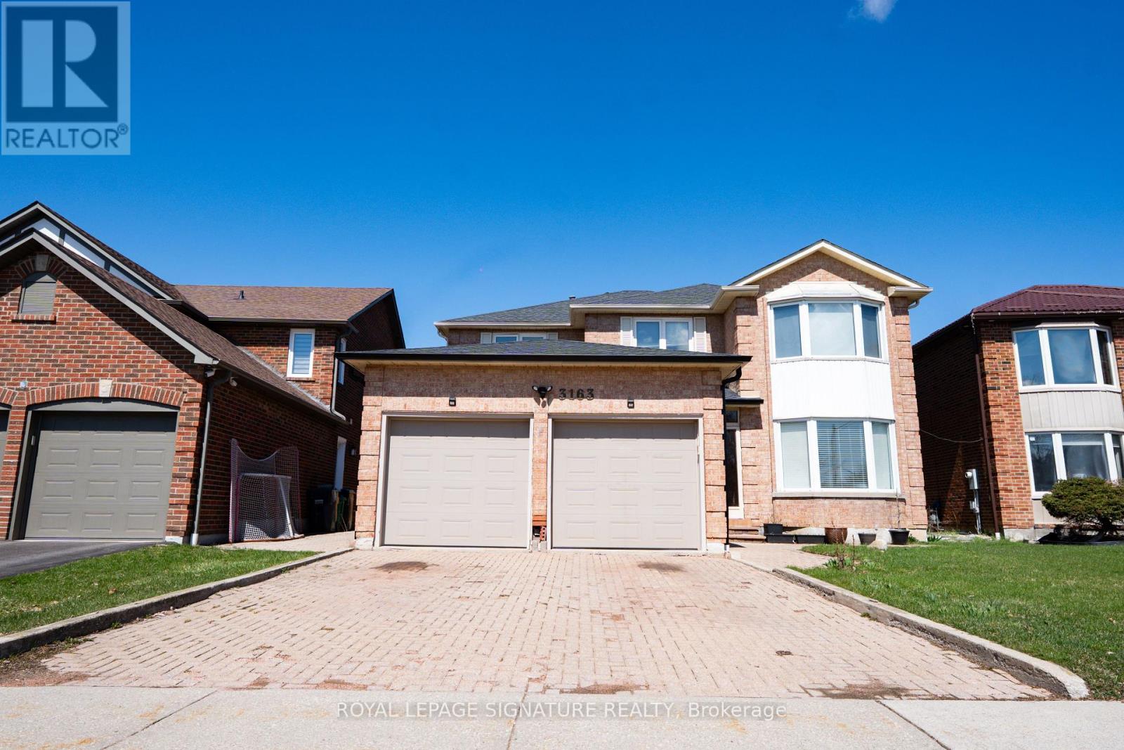 A large, two-story house with a garage is for sale.