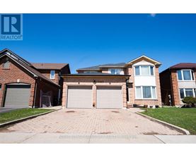 A large, two-story house with a garage is for sale.