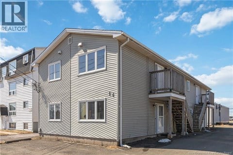 A two-story house with a grey exterior and a balcony on the second floor.