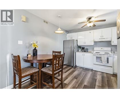 A kitchen with a table and chairs.
