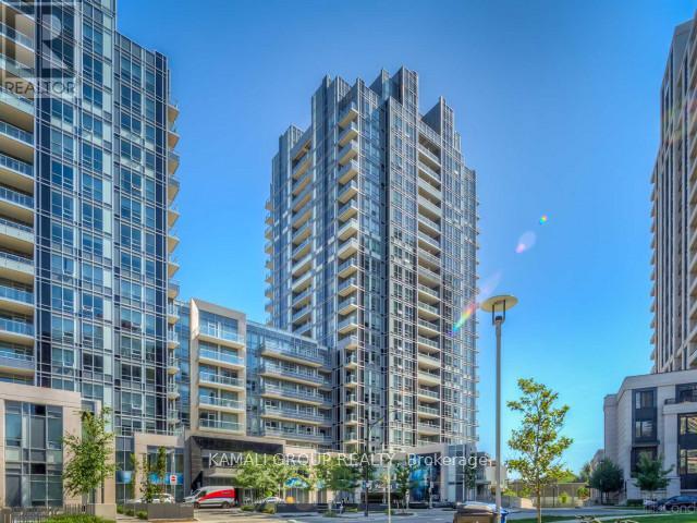 A modern apartment complex with multiple buildings and a clear blue sky.