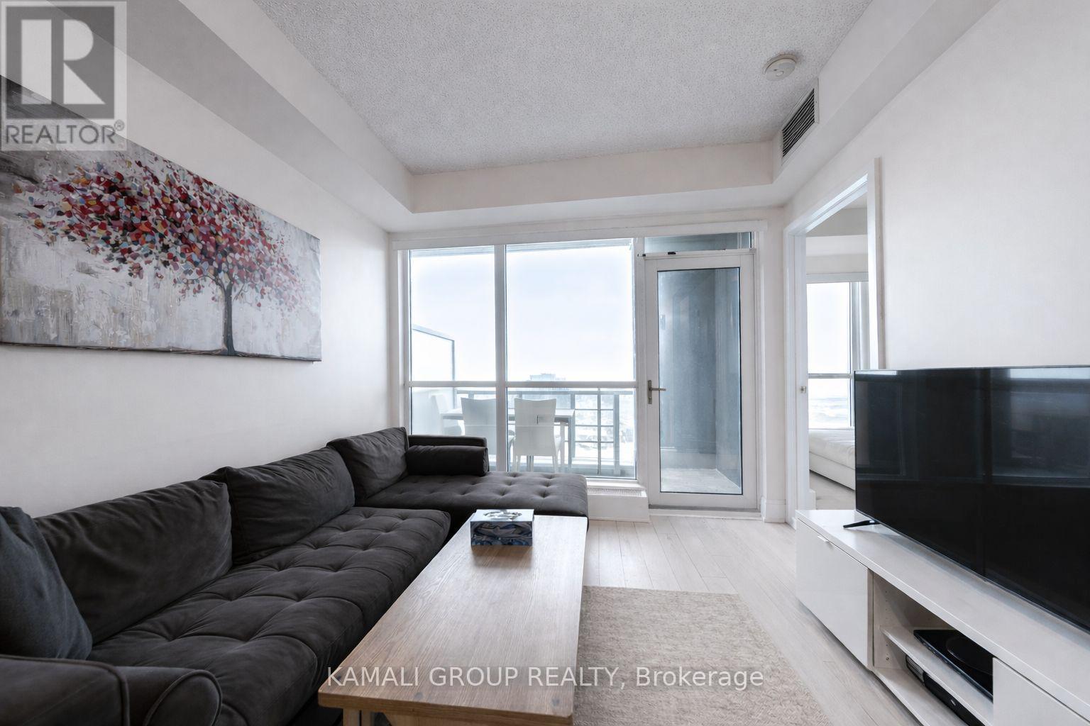 A living room with a grey sofa and a television.