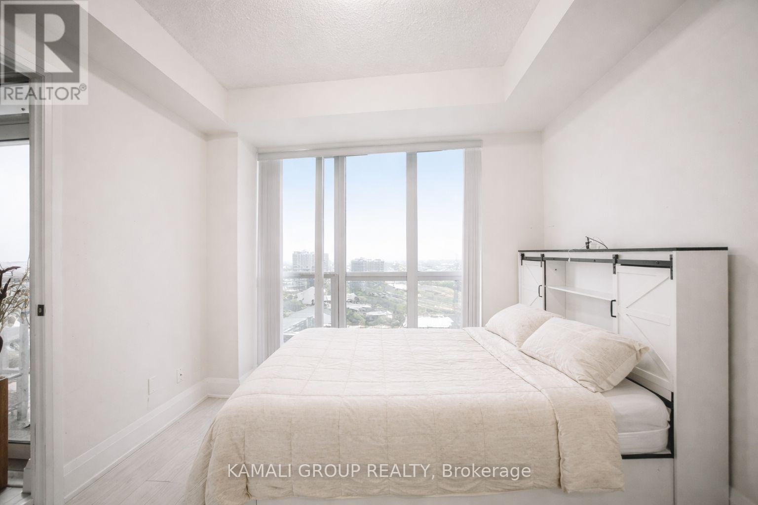 A bedroom with a large bed and a view of the city.