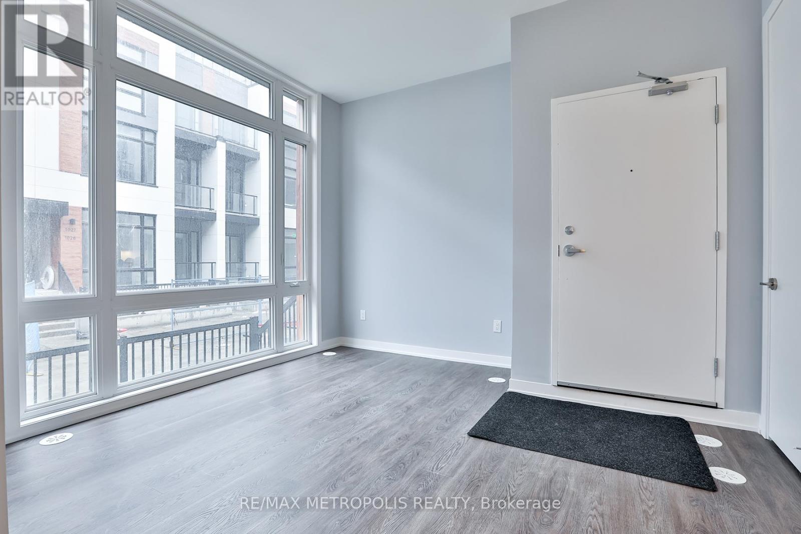 A room with a door and a window overlooking a balcony.