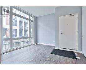 A room with a door and a window overlooking a balcony.