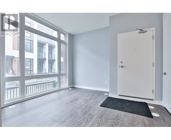 A room with a door and a window overlooking a balcony.