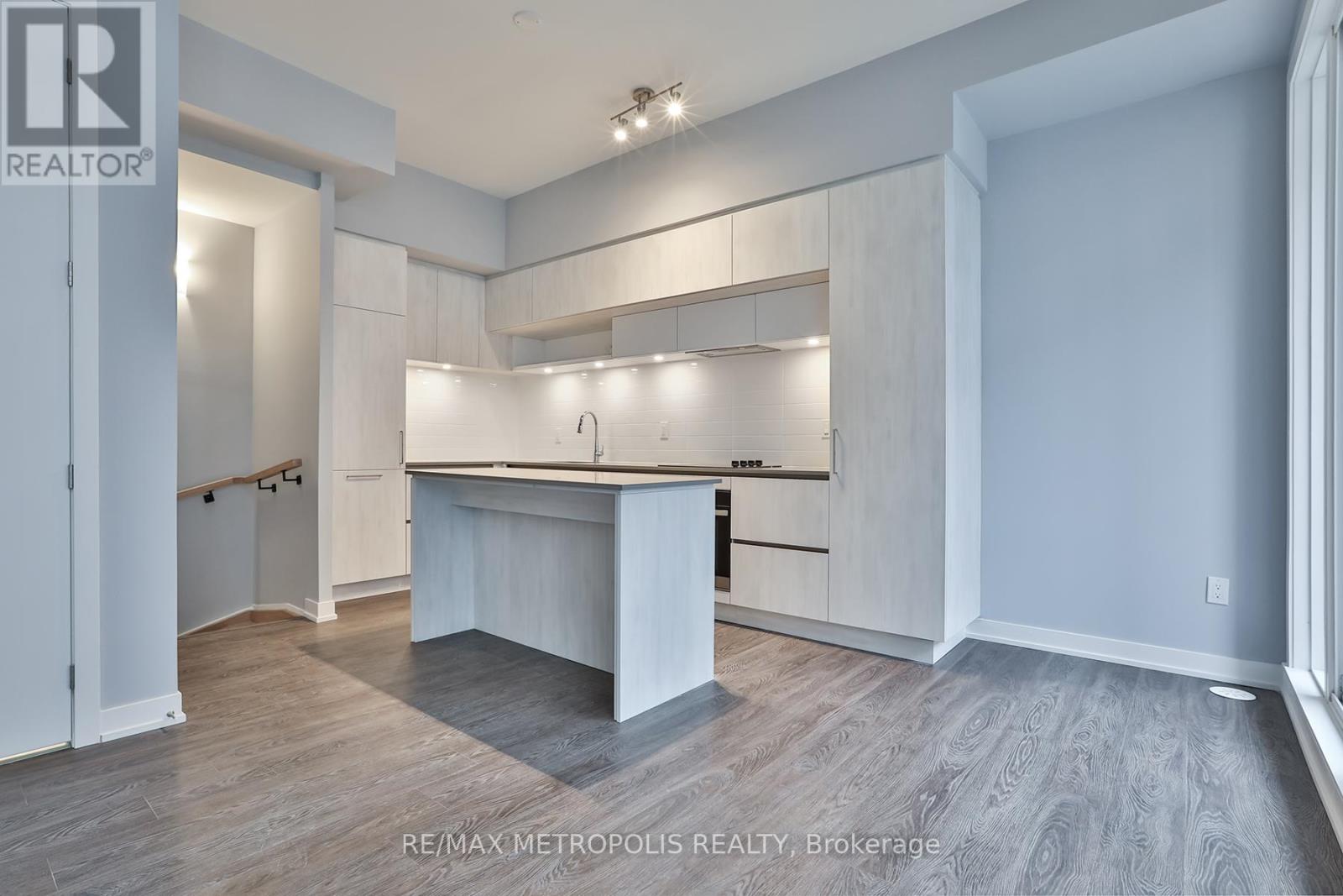 A spacious, well-lit kitchen with white cabinets and a large island.