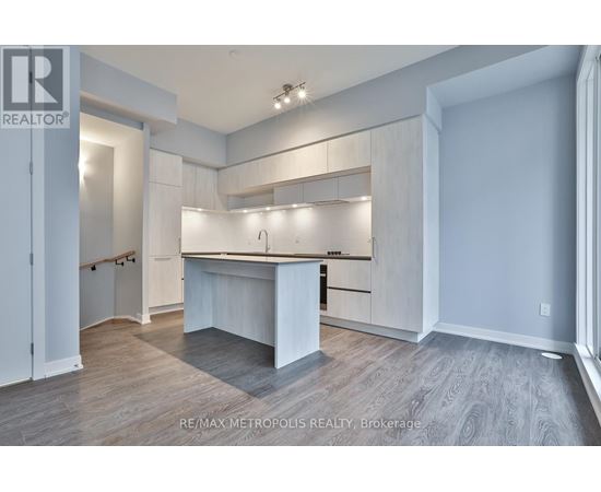 A spacious, well-lit kitchen with white cabinets and a large island.
