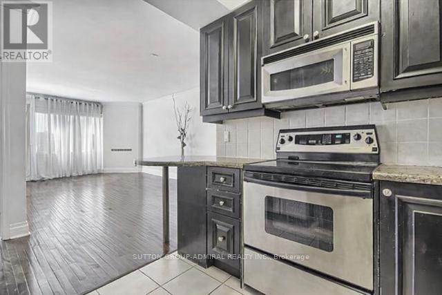 A kitchen with black cabinets and a stove top oven.