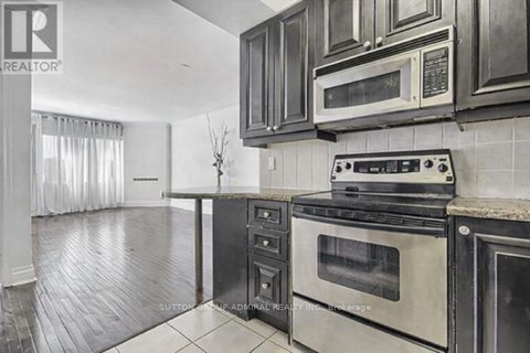 A kitchen with black cabinets and a stove top oven.